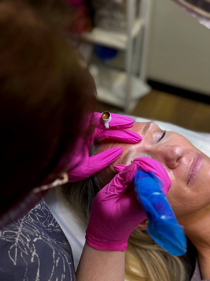 Genevieve at work during an appointment, gloved, with her pigments beside her.
